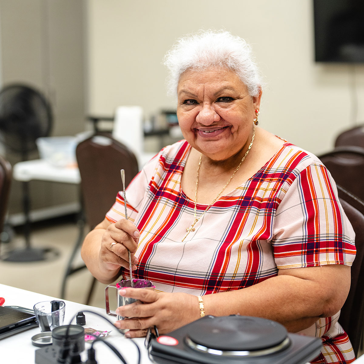 Woman smiling and creating a candle in a craft class