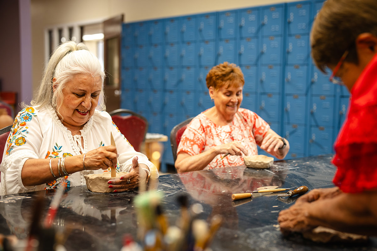 Women enjoying making clay vessels at an arts and crafts class<br />
